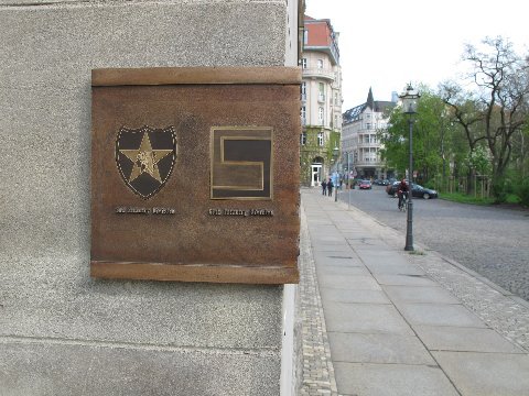 Figure 3: The left part of the plaque (belongs to the image in Fig. 2) at 24 Ditrichring, Leipzig, Germany. Displays the patches of the US 2nd Inf Div and US 69th Inf Div on the left part of the plaque at the corner of the building.